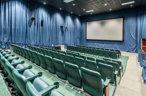 ein leeres Auditorium mit grünen Stühlen und einem Bildschirm in der Unterkunft New BeachFront-Majestic Beach Resort-Starbucks in Panama City Beach + 74 Fotos