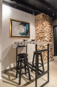 a bar with two stools in front of a brick wall at Inspiring Loft In The Center Of Ciudad Del Este in Ciudad del Este