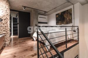 a loft bedroom with a bed and a staircase at Inspiring Loft In The Center Of Ciudad Del Este in Ciudad del Este +20 photos