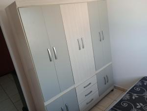 a bedroom with white cabinets and a bed at Apartamento inteiro a 1 minuto da Unesp in Jaboticabal