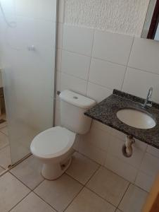 a bathroom with a toilet and a sink at Apartamento inteiro a 1 minuto da Unesp in Jaboticabal
