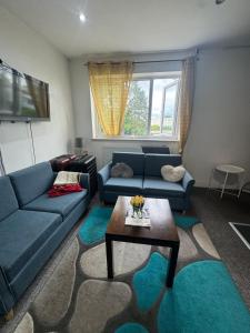 Una sala de estar con un sofá azul y una mesa. en ROOM IN HARROW ON THE Hill, en Harrow