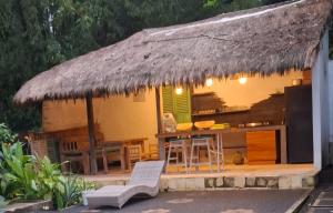 une maison avec un toit de chaume, une table et des chaises dans l'établissement Villa Subak 3 bed room, à Ubud