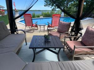 a patio with chairs and a table and a pool at Q Estate Pool cottage in Westport