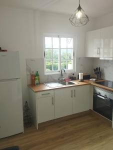 a kitchen with white cabinets and a sink and a window at Green Passion in Ponta Delgada