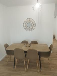 a dining room table with chairs and a clock on the wall at Green Passion in Ponta Delgada +2 photos