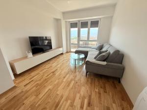 a living room with a couch and a television at EasyStay by Fuat in Struga
