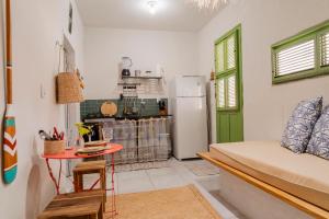 a kitchen with a refrigerator and a table in a room at Chalé dos Ventos Preá - CE in Cruz