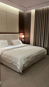 a bedroom with a large bed with white sheets at شقق الخزامى in Al Baha +14 photos