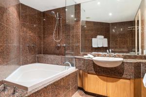 un baño con bañera y lavabo en Mirage Resort Villa 128 with access to Sheraton Facilities, en Port Douglas