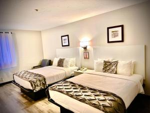 a hotel room with two beds and a table at Heritage House Inn on Cape Cod, an Ascend Collection Hotel in Hyannis +29 photos