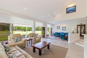 Una sala de estar con sofás y una mesa. en Mirage Resort Villa 134 with access to Sheraton Facilities, en Port Douglas