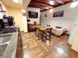 a kitchen and living room with a table and a bed at LA CASA DE FRIDA in Ushuaia