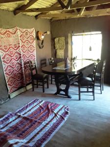 a living room with a table and chairs and a rug at Casa Serena in Yanaoca