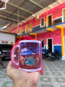 a hand holding a cup with a picture on it at Homestay Lidiya in Banyuwangi