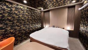 a bed in a room with floral wallpaper at ホテルリンクス in Kashiwa