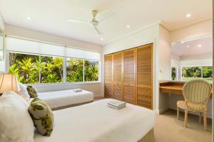 Un dormitorio con dos camas y un escritorio. en Mirage Resort Villa 142 with access to Sheraton Facilities, en Port Douglas