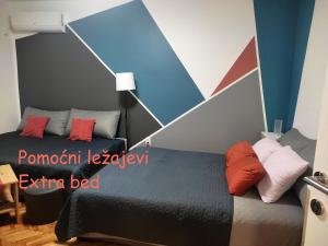 a bedroom with a black bed and red pillows at Ravena in Palić