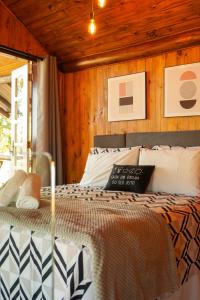 Un dormitorio con una cama con paredes de madera. en Chalé Celeiro em frente ao lago, en Rolante