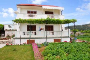 a white house with flowers in front of it at Apartments in Lopar - Insel Rab 17729 in Lopar