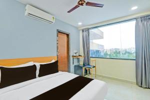 a bedroom with a bed and a large window at Super Townhouse La Vista Inn Grand Hotel in Hyderabad