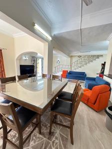 une salle à manger avec une table, des chaises et un canapé dans l'établissement اصنع بعض الذكريات فيلا للإيجار مارينا الساحل الشمالي العلمين, à El Alamein