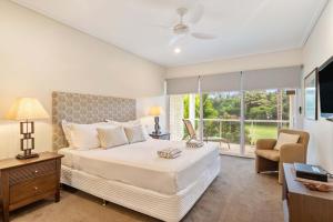 a bedroom with a large bed and a window at Mirage Resort Villa 157 with access to Sheraton Facilities in Port Douglas