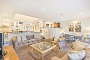 a living room with two couches and a table at Mirage Resort Villa 157 with access to Sheraton Facilities in Port Douglas