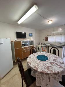 里瓦达维亚海军准将城Suku的一间带桌子的厨房和一间带冰箱的厨房