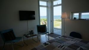 a bedroom with a bed and a view of the ocean at Lunds Hotel in Bogense