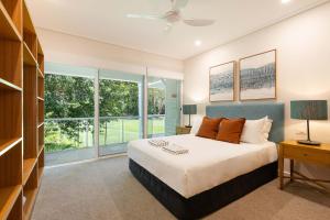 a bedroom with a bed and a large window at Mirage Resort Villa 158 with access to Sheraton Facilities in Port Douglas