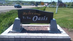 a sign for melbourne to the oasis on the side of a road at Oasis Motel in Antigonish