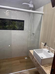 a bathroom with a sink and a glass shower at Morada das colinas in Garanhuns
