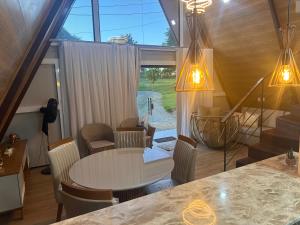 a living room with a table and chairs and a window at Morada das colinas in Garanhuns