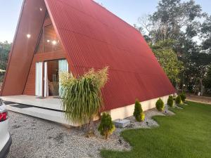 a house with a red roof and some plants at Morada das colinas in Garanhuns
