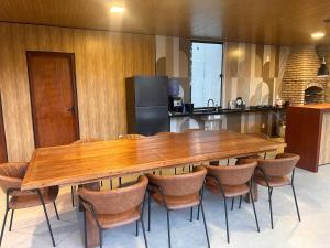 a large wooden table and chairs in a kitchen at Morada das colinas in Garanhuns +14 photos