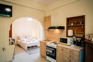 a kitchen with a stove top oven next to a bed at Miranta's Studios in Mytilene