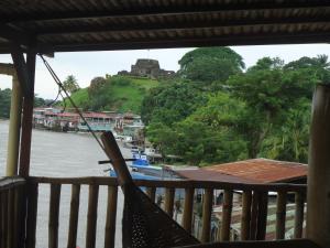 una hamaca en un balcón con vistas al río en Hotel Lara's Planet, en El Castillo de La Concepción