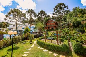 un jardín con una casa en una colina en Vila Husky, en Campos do Jordão