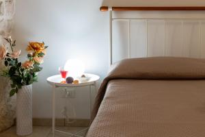 een slaapkamer met een bed en een tafel met een vaas met bloemen bij Maison de Antonelle in Ostuni