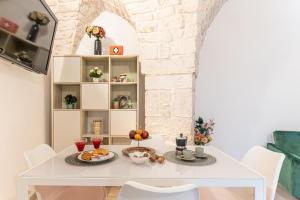 een witte eetkamer met een witte tafel en stoelen bij Maison de Antonelle in Ostuni +26 foto's