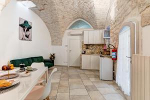 een keuken en woonkamer met een tafel en stoelen bij Maison de Antonelle in Ostuni