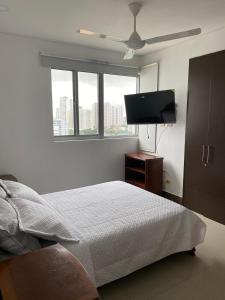 a bedroom with a bed and a flat screen tv at El Cabrero- balcon con vista a la muralla y La Popa in Cartagena de Indias