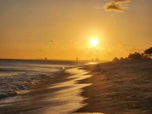 a beach with the sun setting in the distance at Oceanfront, Caracol Beach in Chame +26 photos