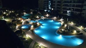 a large swimming pool at night with lights at Oceanfront, Caracol Beach in Chame