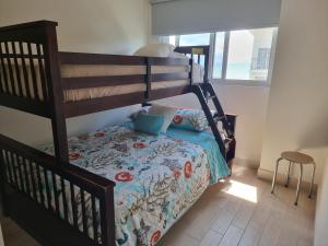a bedroom with a bunk bed with a bedspread on it at Oceanfront, Caracol Beach in Chame
