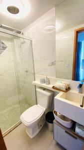 a bathroom with a toilet and a shower and a sink at Flat de luxo em frente ao mar in João Pessoa