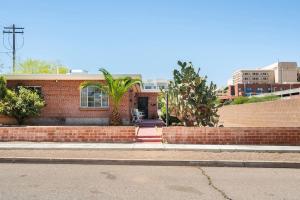 a brick house with a palm tree in front of it at Spring Escape 1BR by UA DT Just 2 Min to Banner in Tucson