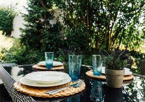 a table with plates and glasses on top at Appartamentino - Stilvolle Einliegerwohnung nahe Freiburg in Heuweiler