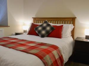 een slaapkamer met een groot bed met rode kussens bij Rockfish Cottage in Brixham